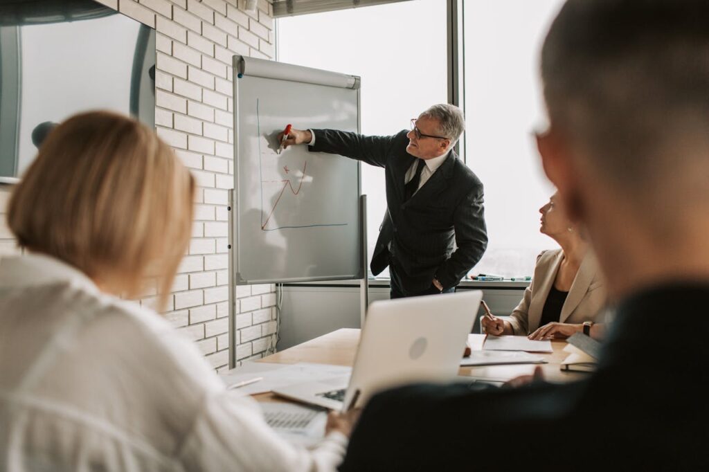 A confident professional presenting ideas in a modern office, with colleagues attentively listening, symbolizing workplace influence and leadership.